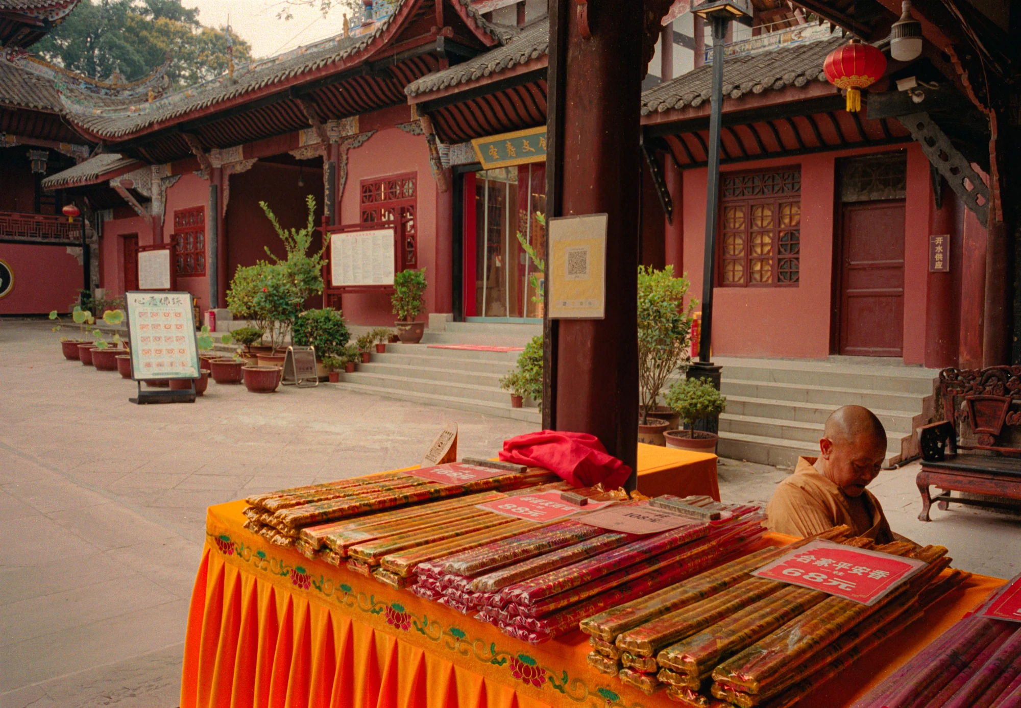 Un monaco e un banco di incensi nel cortile di un tempio in Cina.