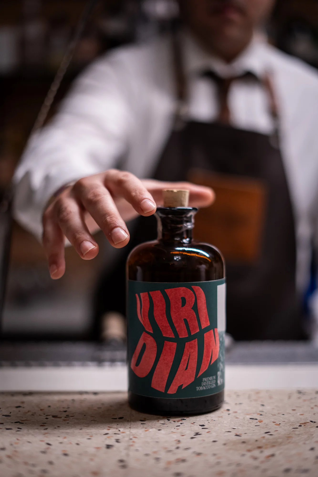 Il gesto del bartender che prende la bottiglia Viridian.