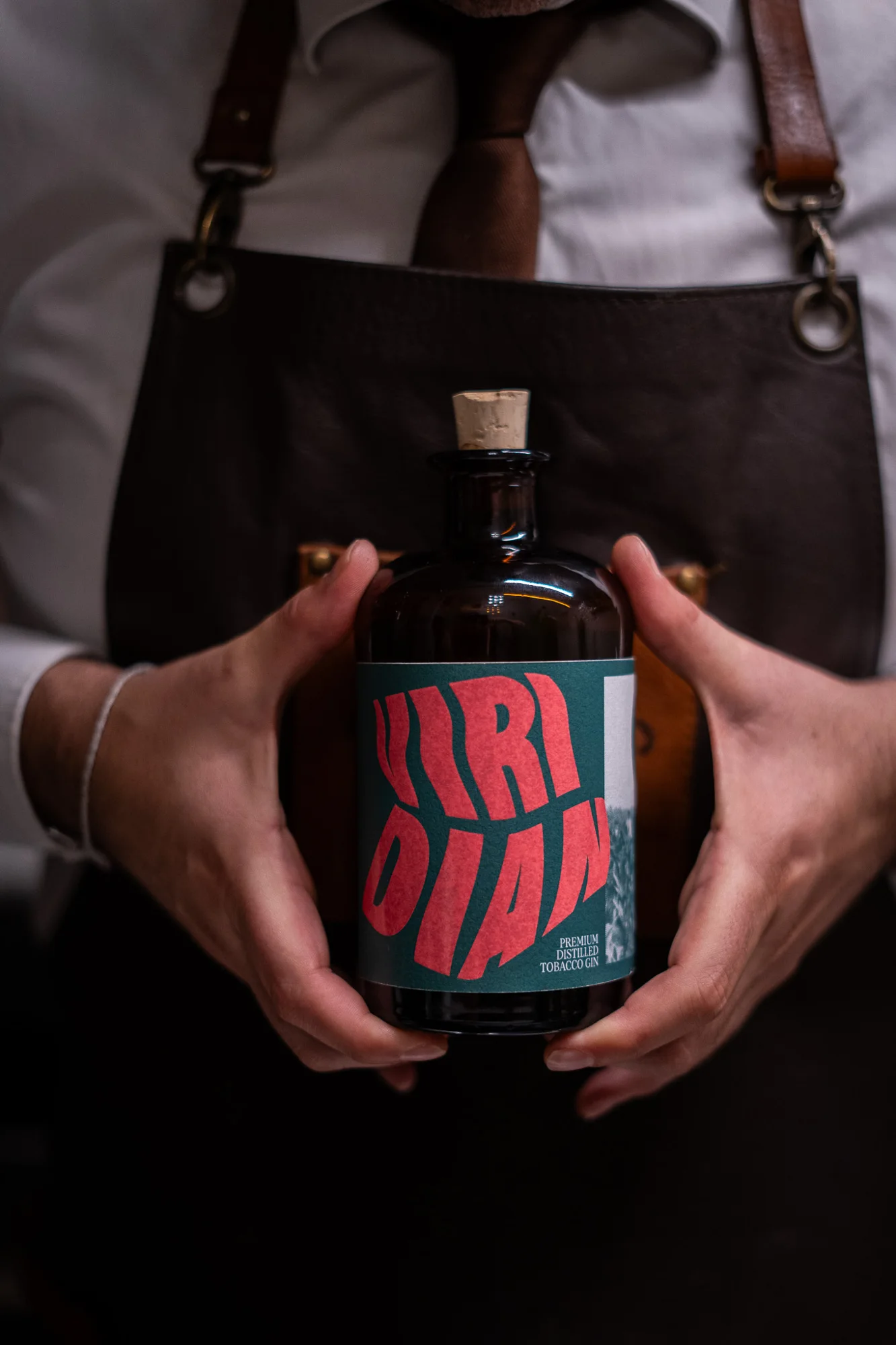 La bottiglia Viridian tra le mani del bartender.