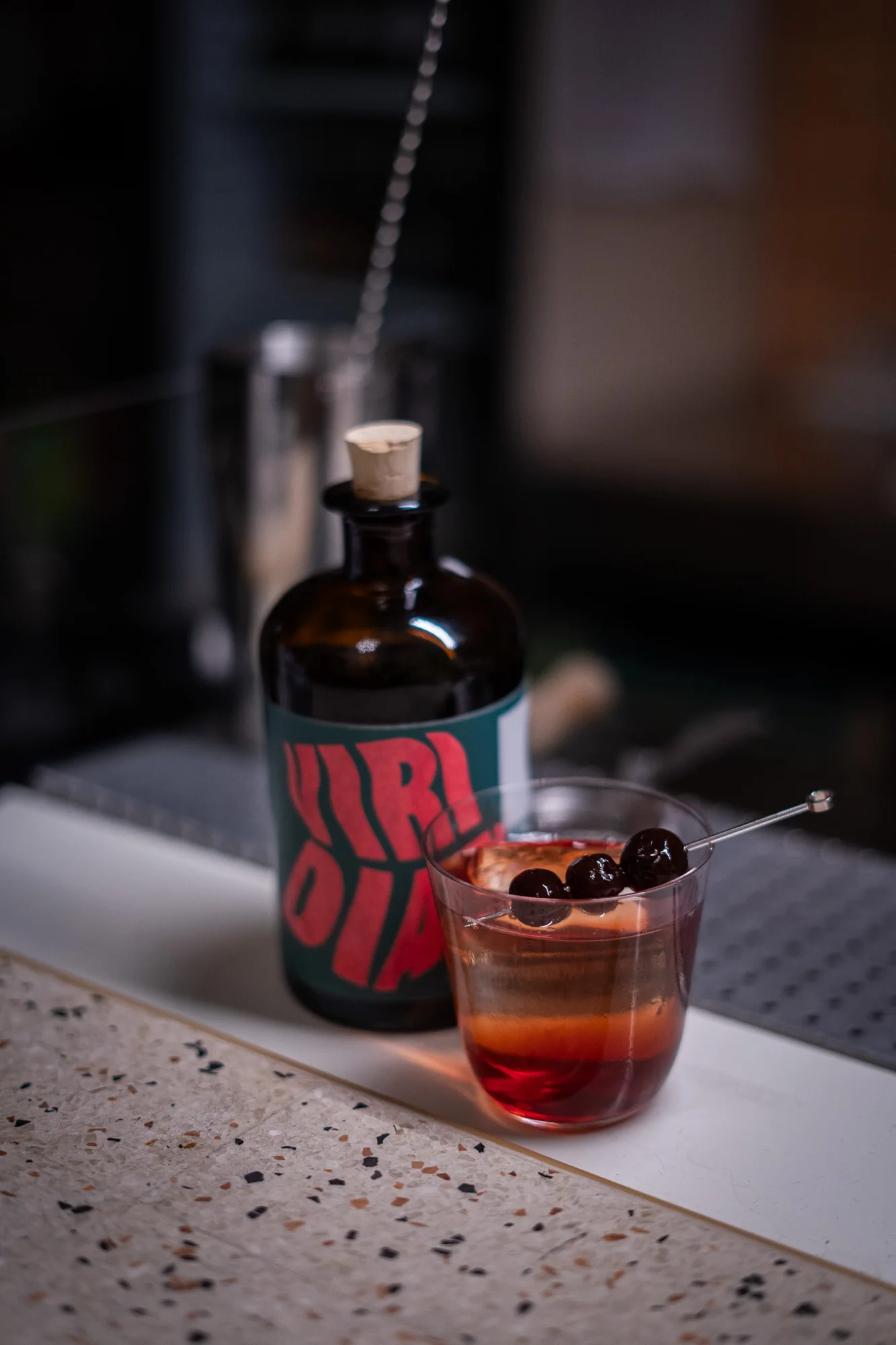 Un cocktail e la bottiglia Viridian sul banco.